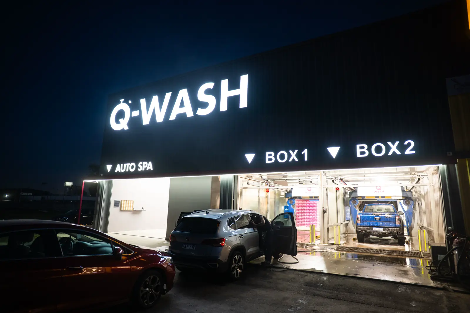 Los dos boxes de lavado de Q-WASH de noche, con autos adentro